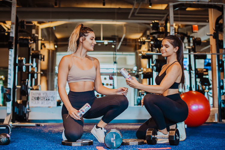 image of a women working out holding celsius cans